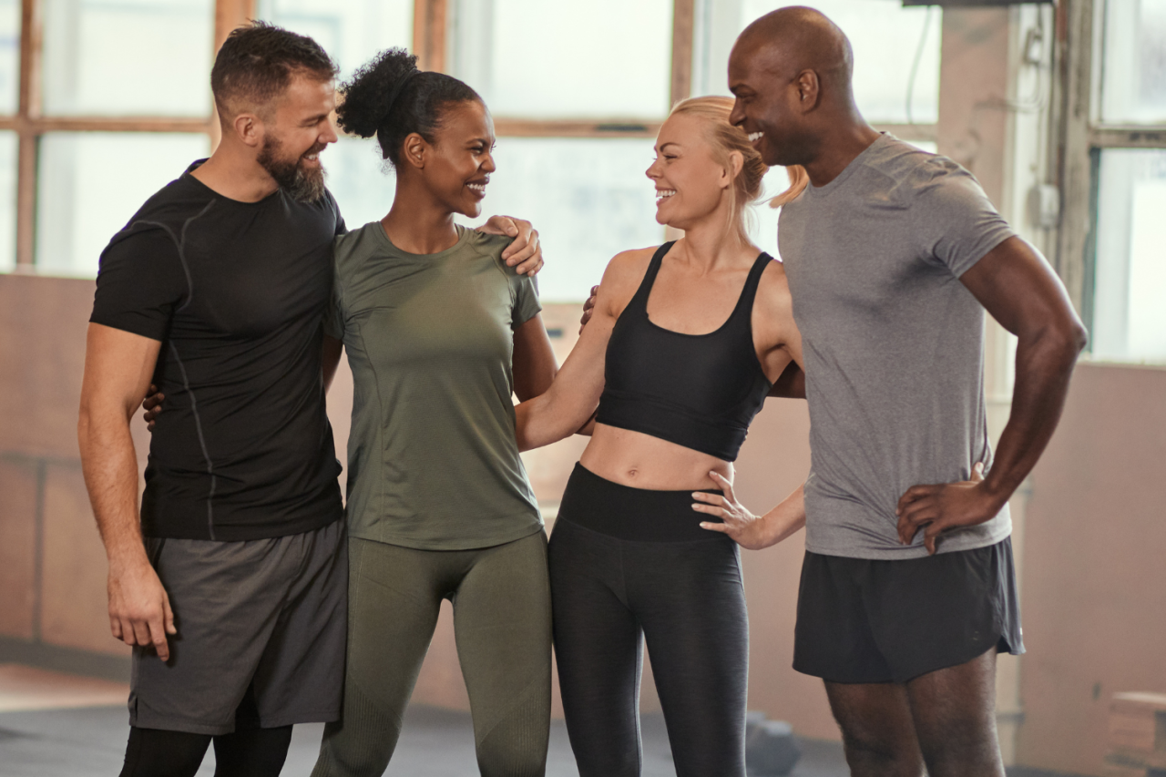 People supporting each other during a fitness workout session to highlight the benefits of accountability in fitness.